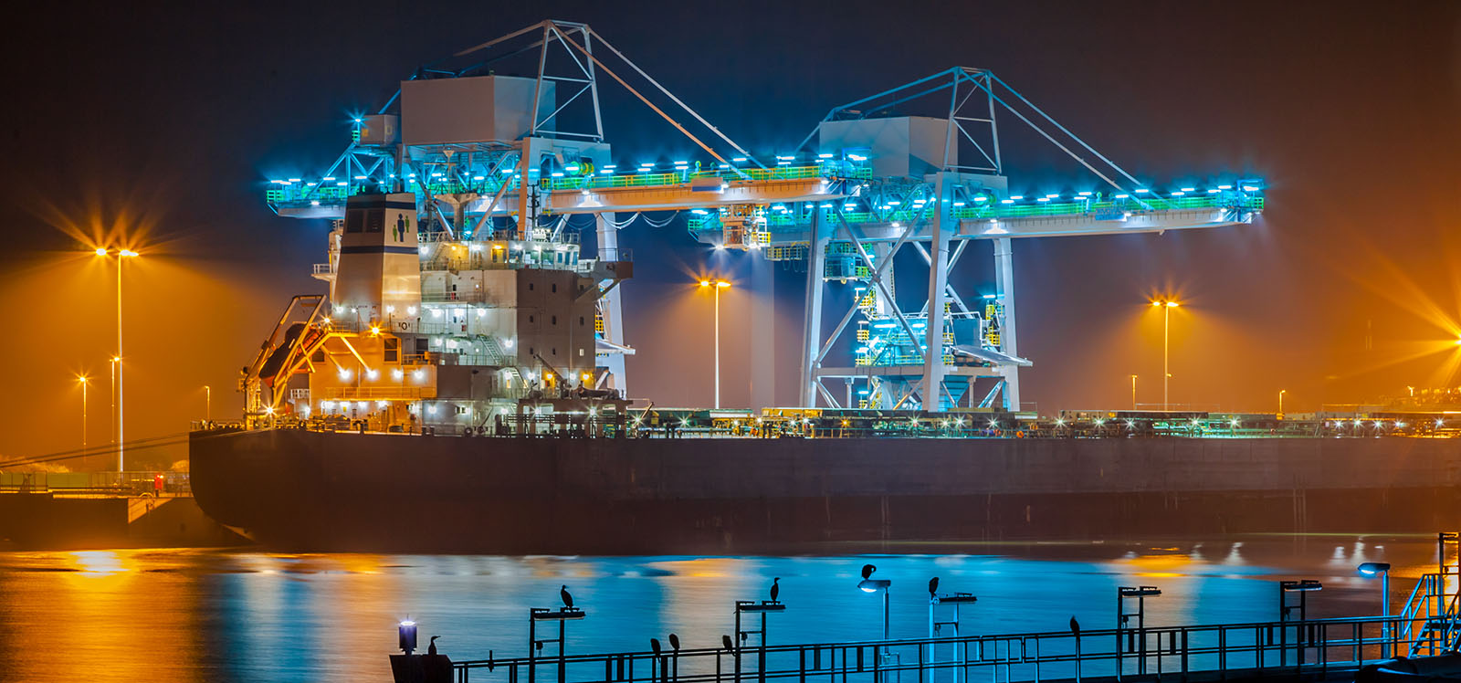 navio no porto à noite iluminado pelas luzes do lugar